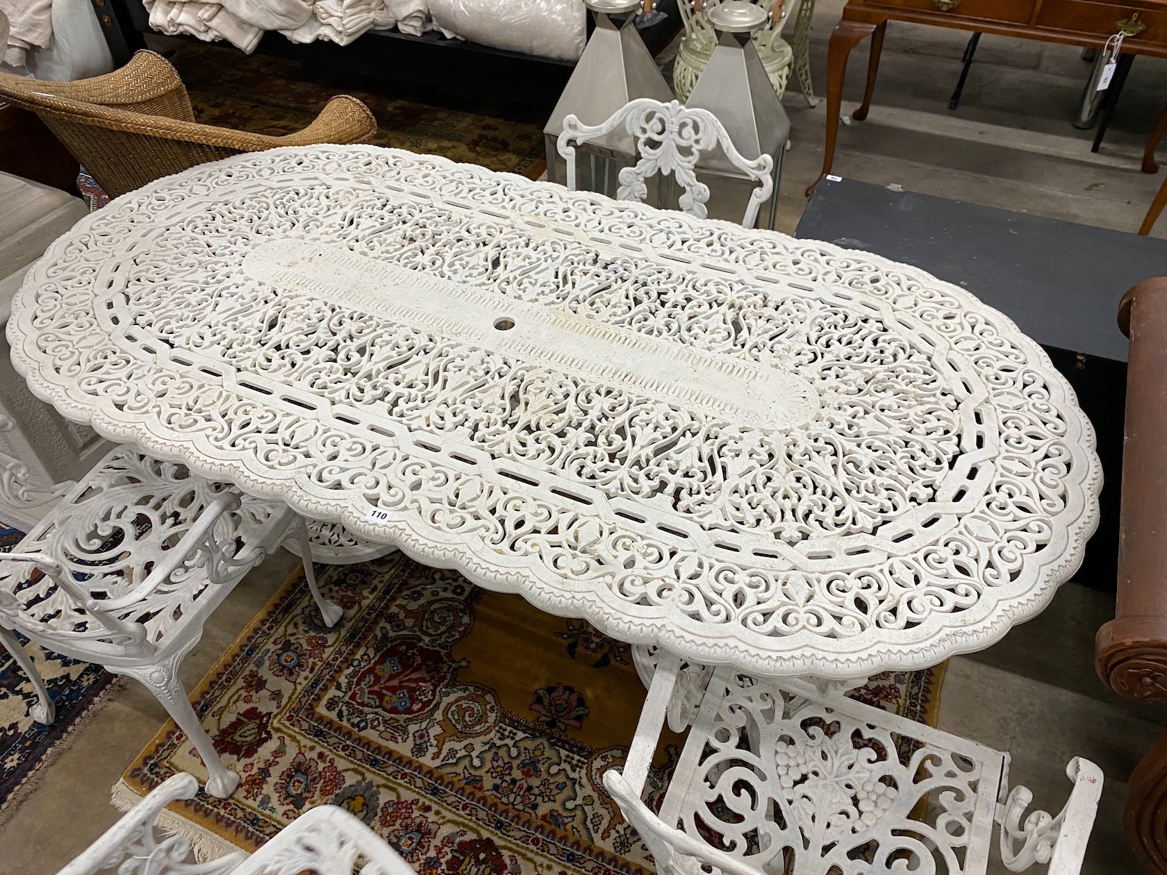 A Victorian style painted cast aluminium garden table, length 180cm, width 90cm, height 72cm and four matching elbow chairs